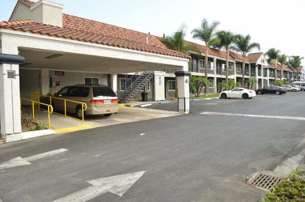 a car parked in a parking lot next to a building at Welcome Inn Corona in Corona