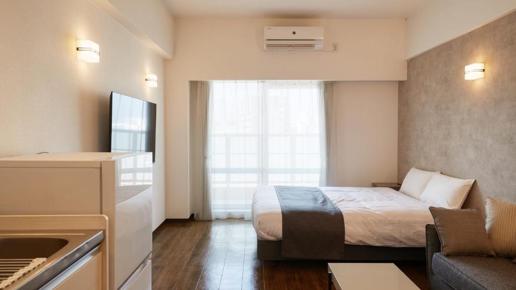 New Normal Hotel in NAMINOUE ニューノーマルホテルイン波の上客房内的一张或多张床位