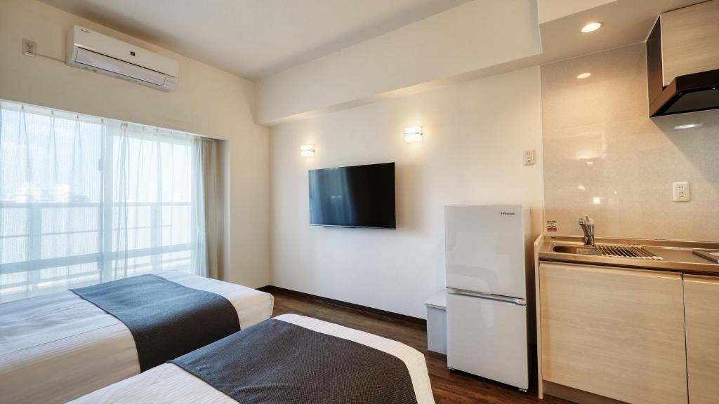 New Normal Hotel in NAMINOUE ニューノーマルホテルイン波の上客房内的一张或多张床位