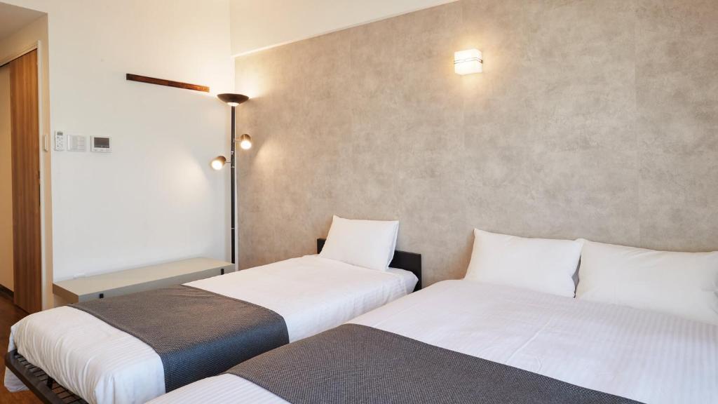 New Normal Hotel in NAMINOUE ニューノーマルホテルイン波の上客房内的一张或多张床位