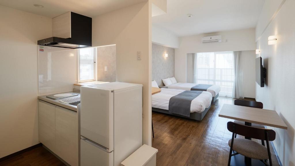 New Normal Hotel in NAMINOUE ニューノーマルホテルイン波の上客房内的一张或多张床位
