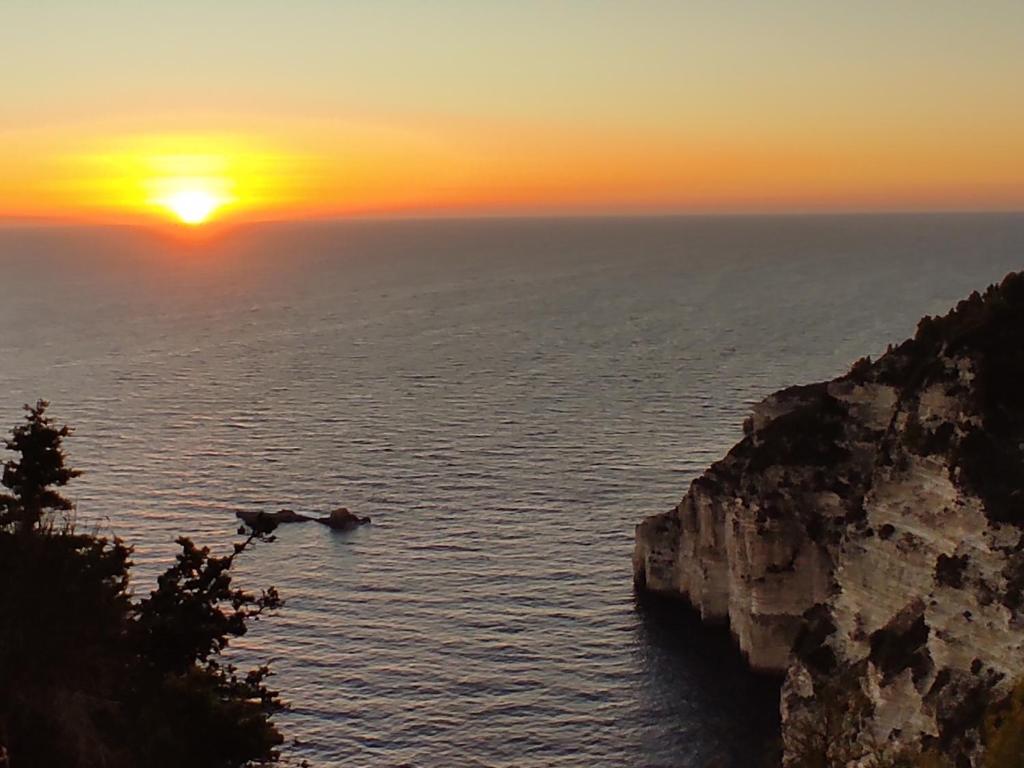 a sunset over the ocean with a cliff at Villa Olive Garden, Kastanida - Paxoi in Gaios
