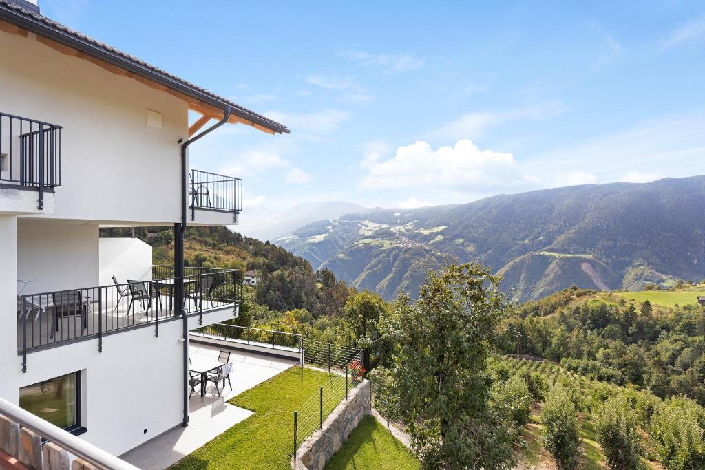 uma casa com uma varanda com vista para as montanhas em Thalerhof Naturae Rupes em Auna di Sotto