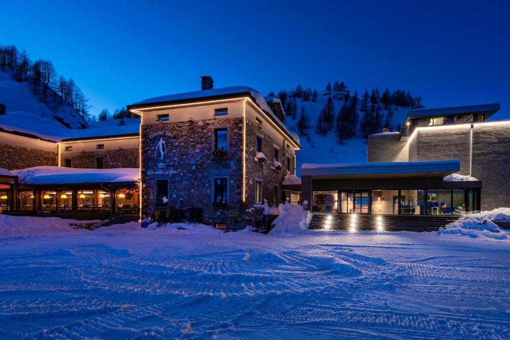 un edificio en la nieve por la noche en Re Delle Alpi Resort & Spa, 4 Stelle Superior, en La Thuile