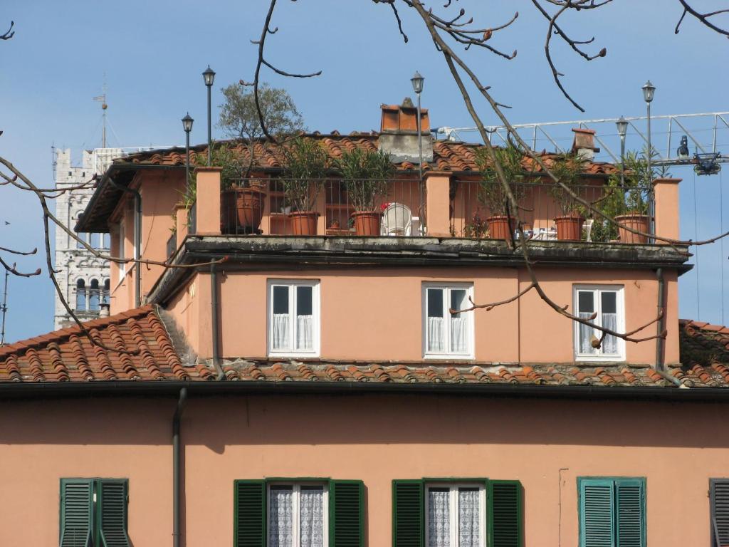 un edificio con persianas verdes y techo en Le MURA MEDIEVALI, en Lucca