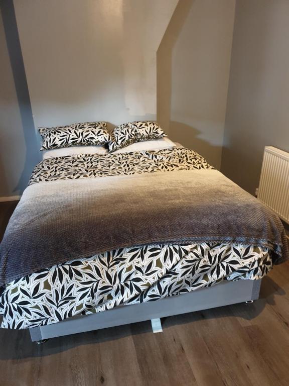 a bed with black and white sheets and pillows at AG HOUSE in Manchester