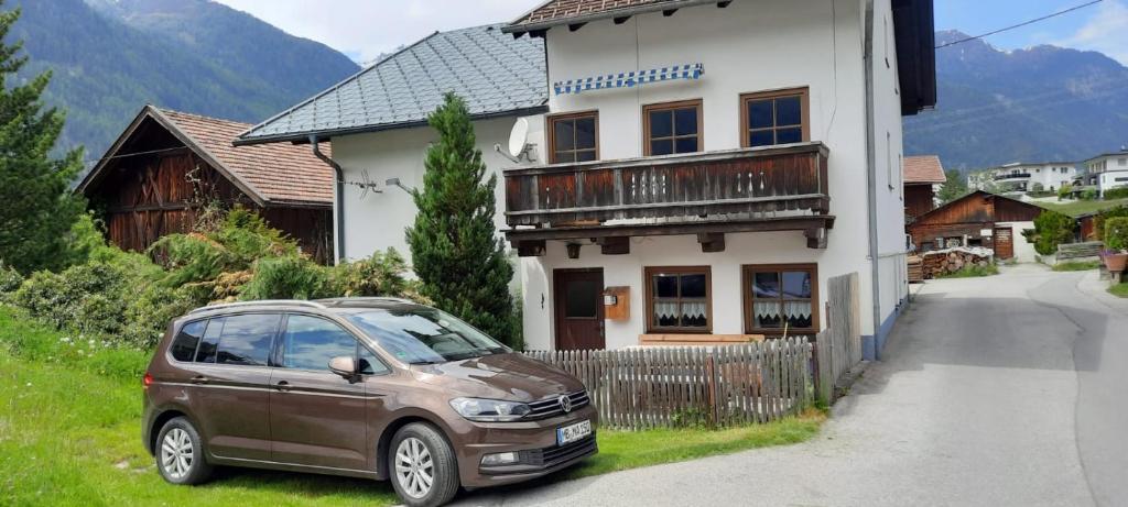 een kleine auto geparkeerd voor een huis bij Maridl`s Ferienhaus in Umhausen