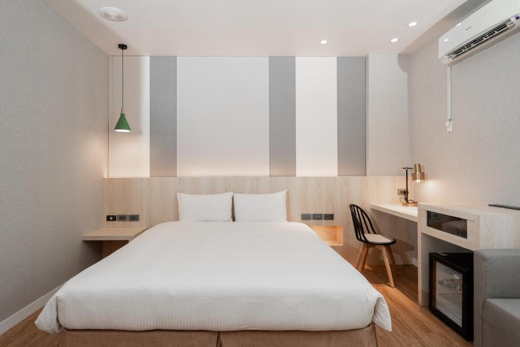 宜蘭市的住宿－宜蘭富翔大飯店，卧室配有一张白色大床和一张书桌