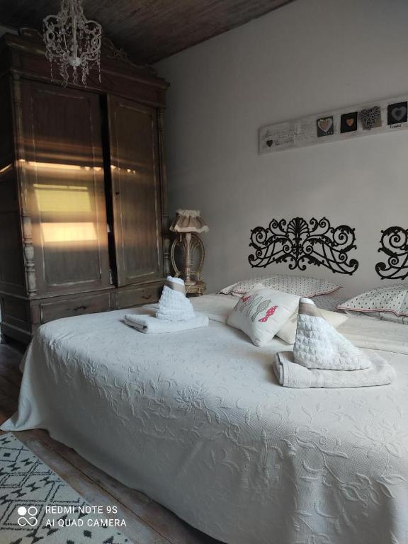 a bedroom with a large bed with white sheets and pillows at chambre au mont scolan in Montgardon