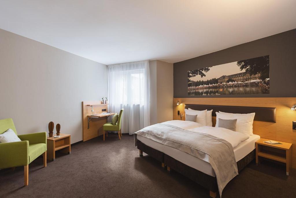 una habitación de hotel con una cama grande y una silla en Novum Hotel Bruy, en Stuttgart