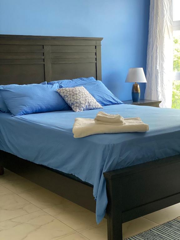 
a bed that has a blue blanket on it at Home Away From Home in Kingston
