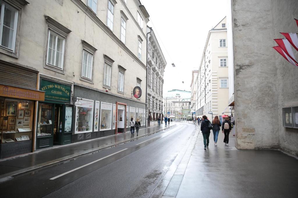 eine Gruppe von Menschen, die eine Stadtstraße entlang laufen in der Unterkunft Heart of Vienna- next to Albertina in Wien