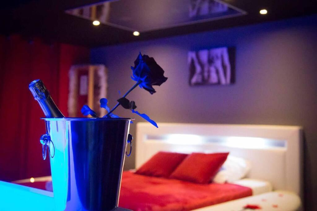 una taza azul con cepillos de dientes delante de la cama en Gîte Love Dream - Le Gîte Romantique, en Ger