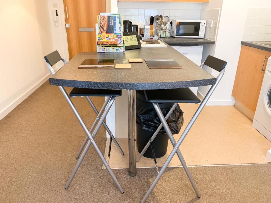 a kitchen island with two chairs and a counter top at Glasgow City Centre Studio Apartment in Glasgow