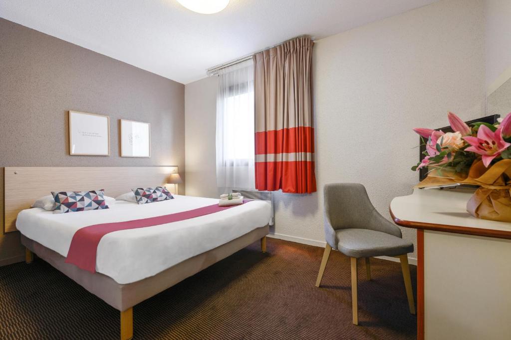 Pokój hotelowy z łóżkiem i krzesłem w obiekcie Appart'City Classic Nantes Viarme w mieście Nantes