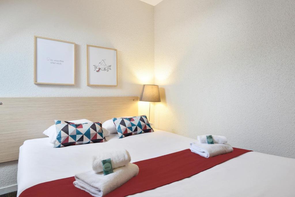 a hotel room with two beds with towels on them at Appart'City Classic Nantes Viarme in Nantes