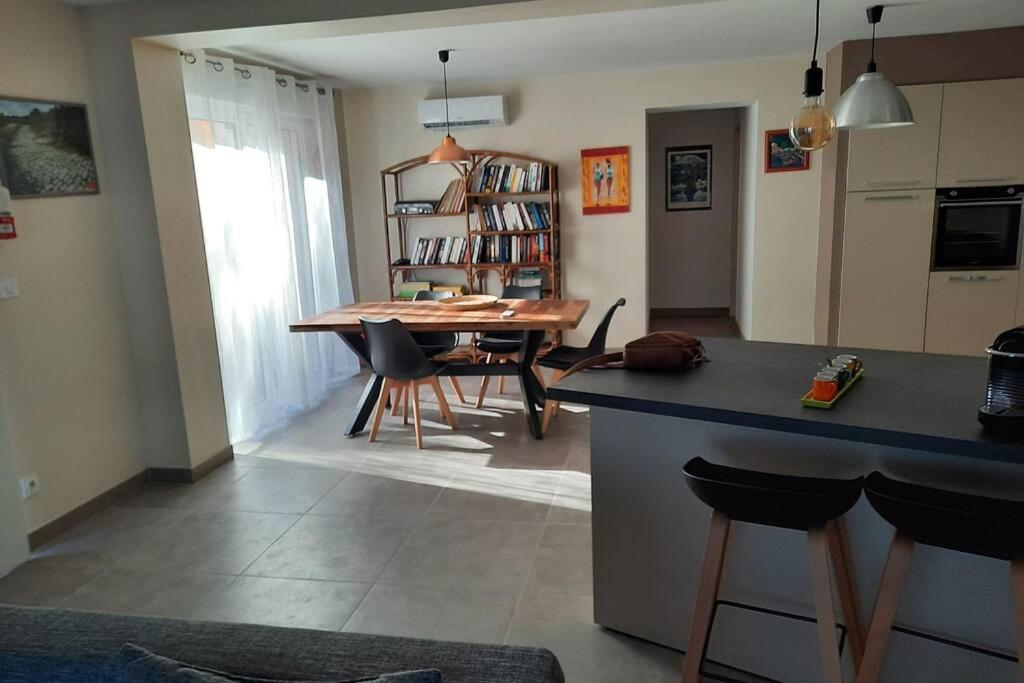 a kitchen and dining room with a table and chairs at SUPERBE VILLA 85 m2 NIMES CAREMEAU in Nîmes