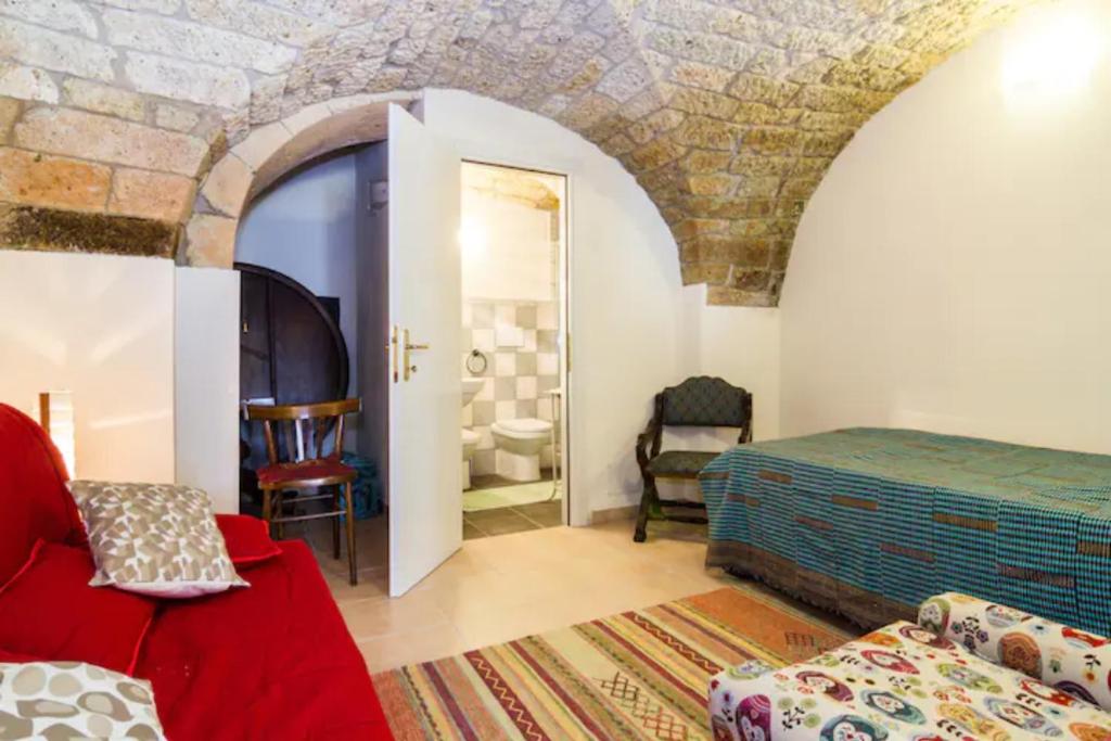 クーリエリにあるCasa Blùの赤いベッドと石の壁が備わるベッドルーム1室