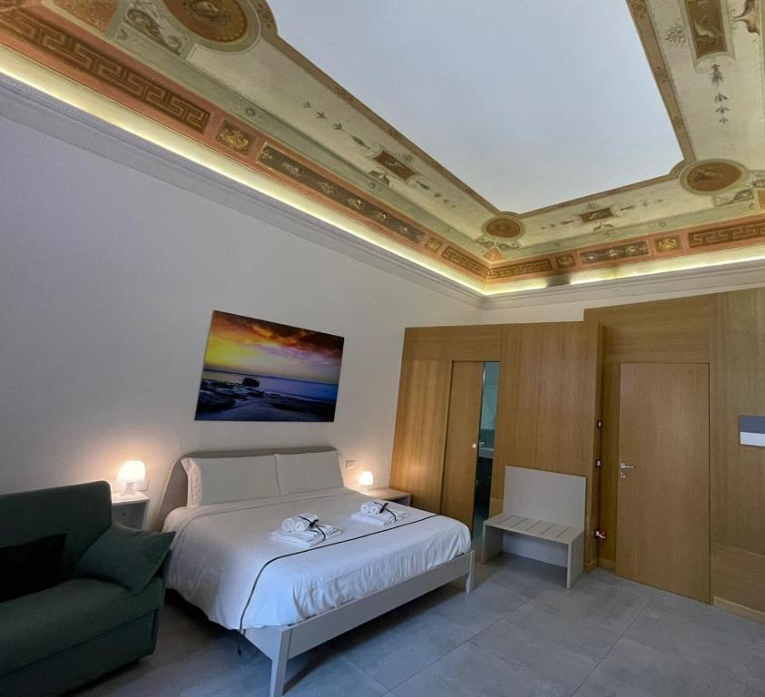 Le Quattro Stagioni - Rooms & Suite في باليرمو: غرفة نوم بسرير واريكة