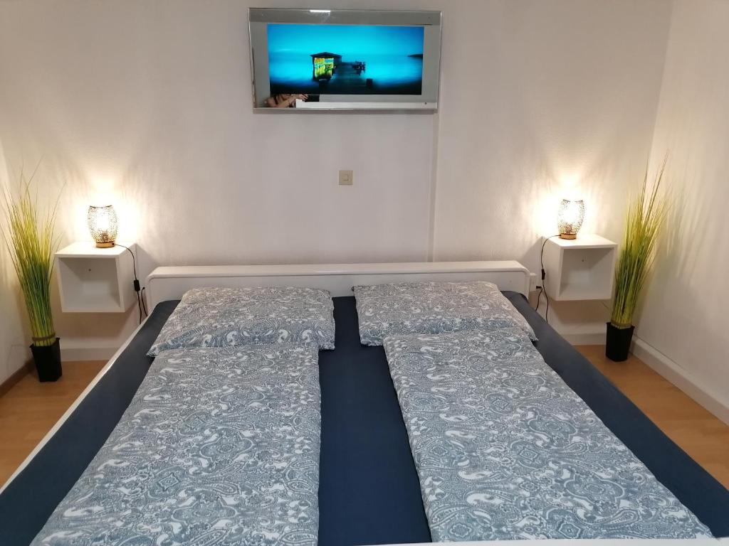 Cama en habitación con TV en la pared en Thomas Haus en Günzburg