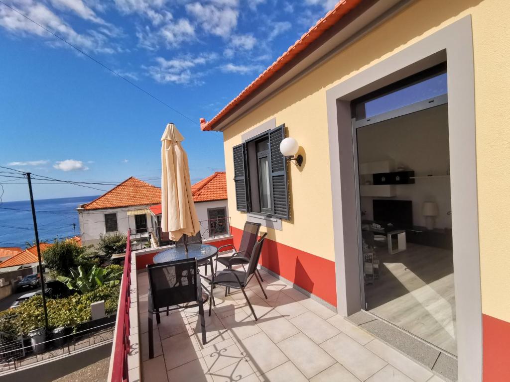 uma varanda de uma casa com uma mesa e cadeiras em Charming Apartment in Funchal – Lazareto no Funchal