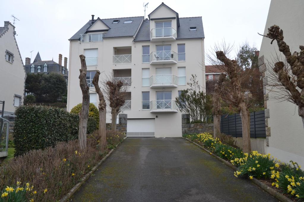 um edifício de apartamentos branco com uma entrada em pleneuf val andre appart vue mer 2 à 4 personnes em Pléneuf-Val-André