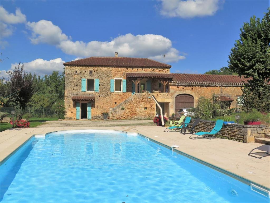 una casa con piscina di fronte a un edificio di Holiday Home Les Grèzes - MNB400 by Interhome a Montcabrier