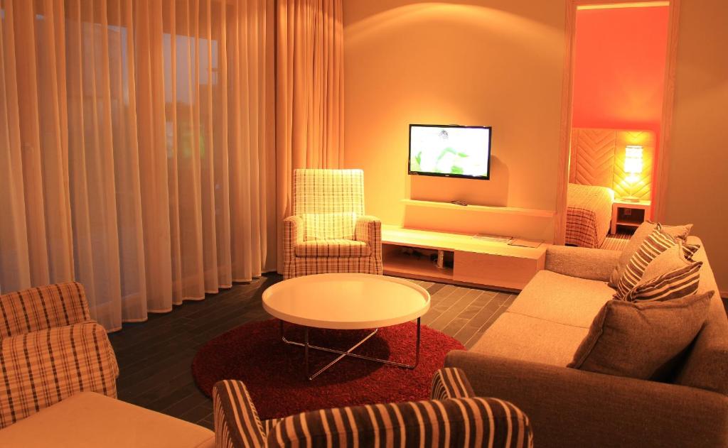 sala de estar con sofá, sillas y TV en Kaluri Residence, en Kuressaare