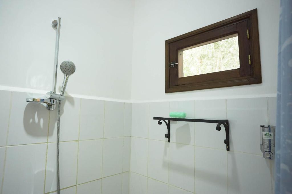 a bathroom with a shower with a window at Andasibe Lemurs Lodge in Andasibe