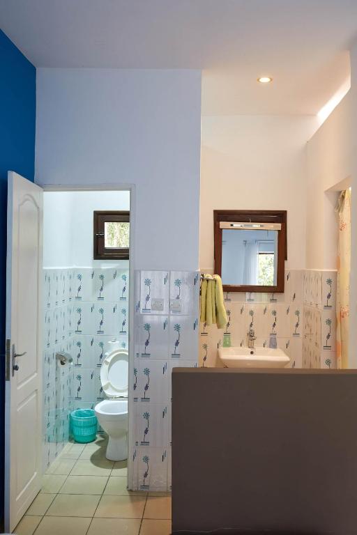 a bathroom with a toilet and a sink at Andasibe Lemurs Lodge in Andasibe