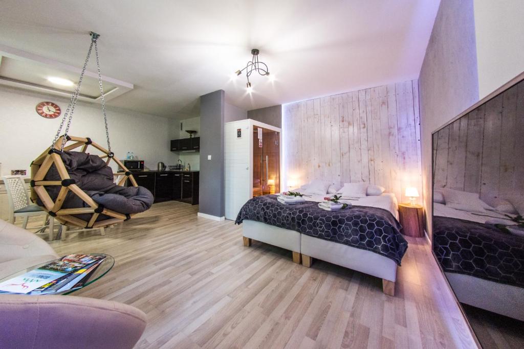 カルパチにあるApartamenty hoteLOVE z saunąのベッドルーム1室(ベッド1台付)、リビングルームが備わります。