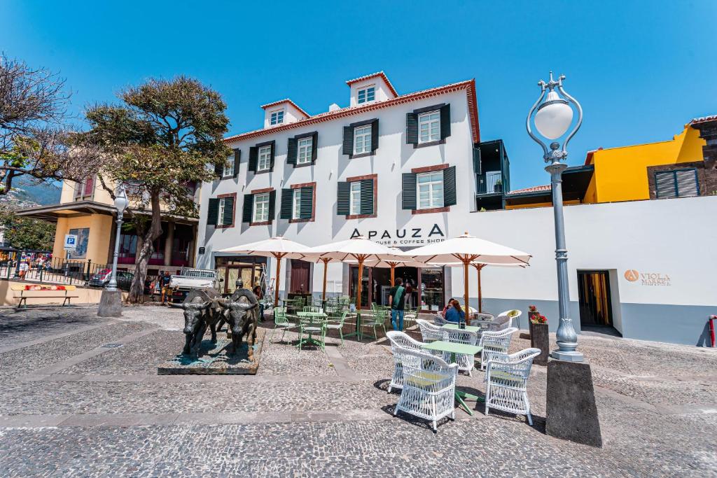 um edifício com mesas e cadeiras e uma luz de rua em FLH Viola Market Studios no Funchal