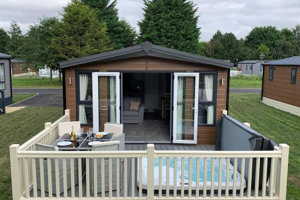 a gazebo with a table and chairs on a deck at Nightingale Lodge with Hot Tub in Barmby on the Moor