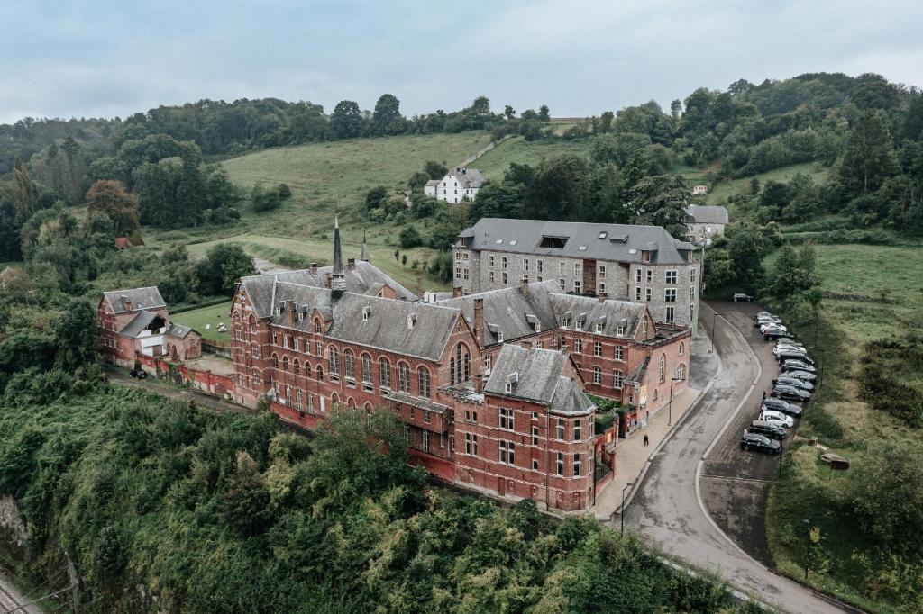 une vue aérienne sur un ancien bâtiment en briques rouges dans l'établissement La Merveilleuse by Infiniti hôtel, à Dinant