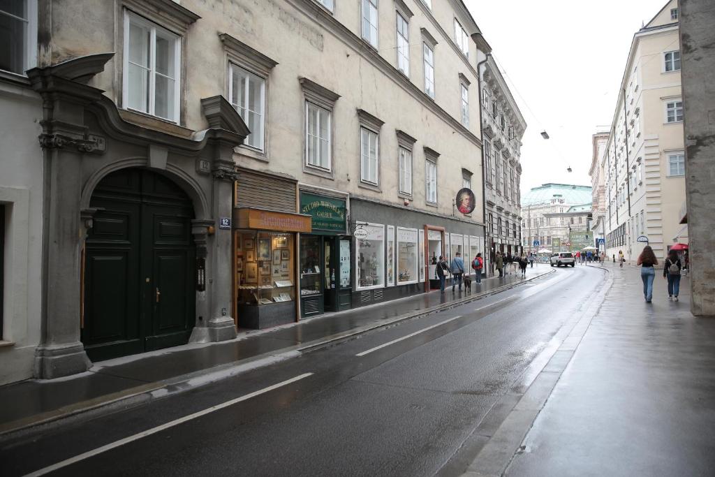 an empty city street with people walking on the sidewalk at Heart of Vienna - City Apartment in Vienna