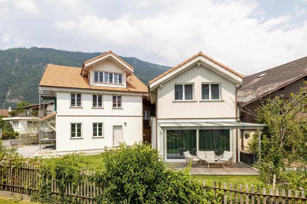 ein weißes Haus mit einem Zaun in der Unterkunft Eiche in Interlaken