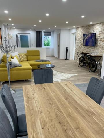 een woonkamer met een tafel en een gele bank bij außergewöhnliche Kellerloft in Innsbruck