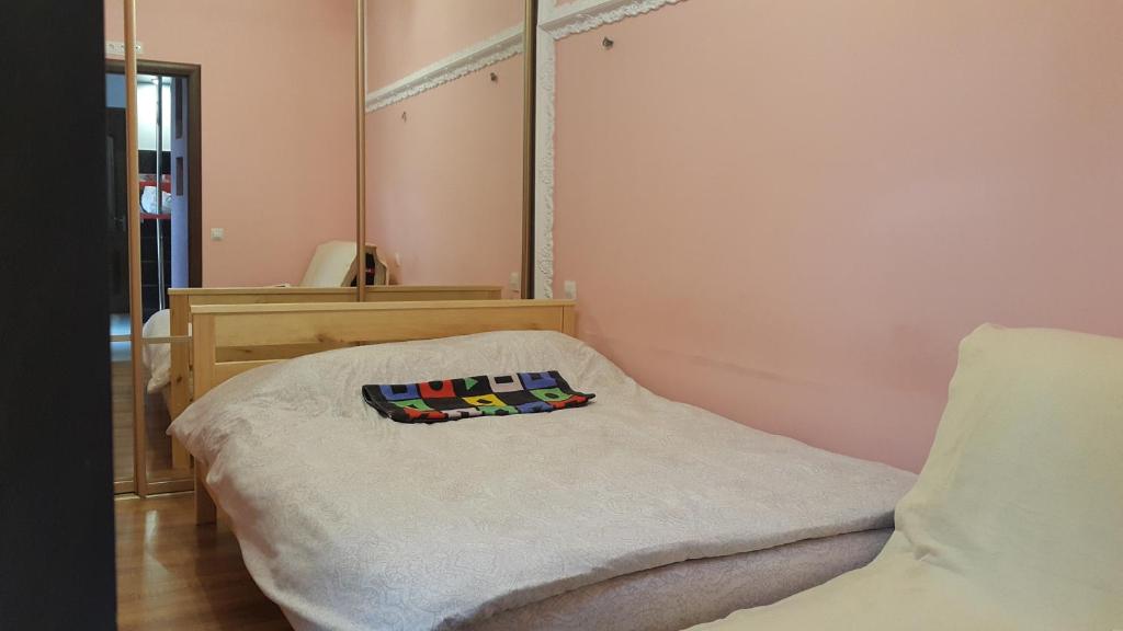 um pequeno quarto com uma cama e um espelho em VOLBIL em Lviv