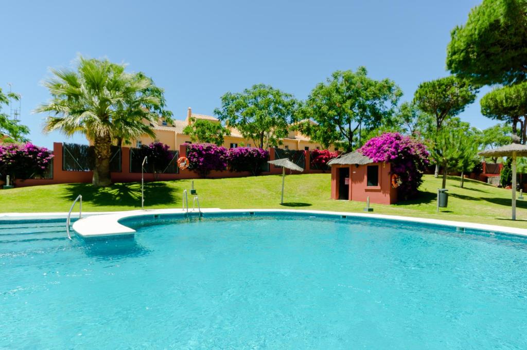 a large swimming pool in a yard with a building at Apartamentos O2 El Puerto in El Puerto de Santa María