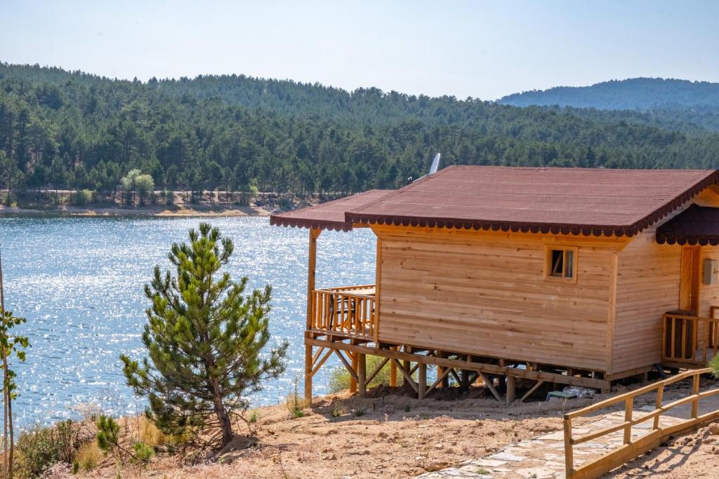 Tahtalı Göl Evleri في إيميت: كابينة خشبية على شاطئ البحيرة