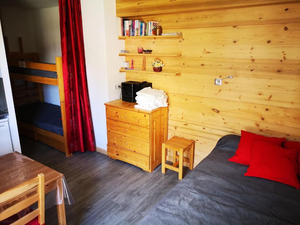 a bedroom with a bed and a wooden wall at Borsat - Beau Studio 4pax sur les pistes, avec balcon in Tignes