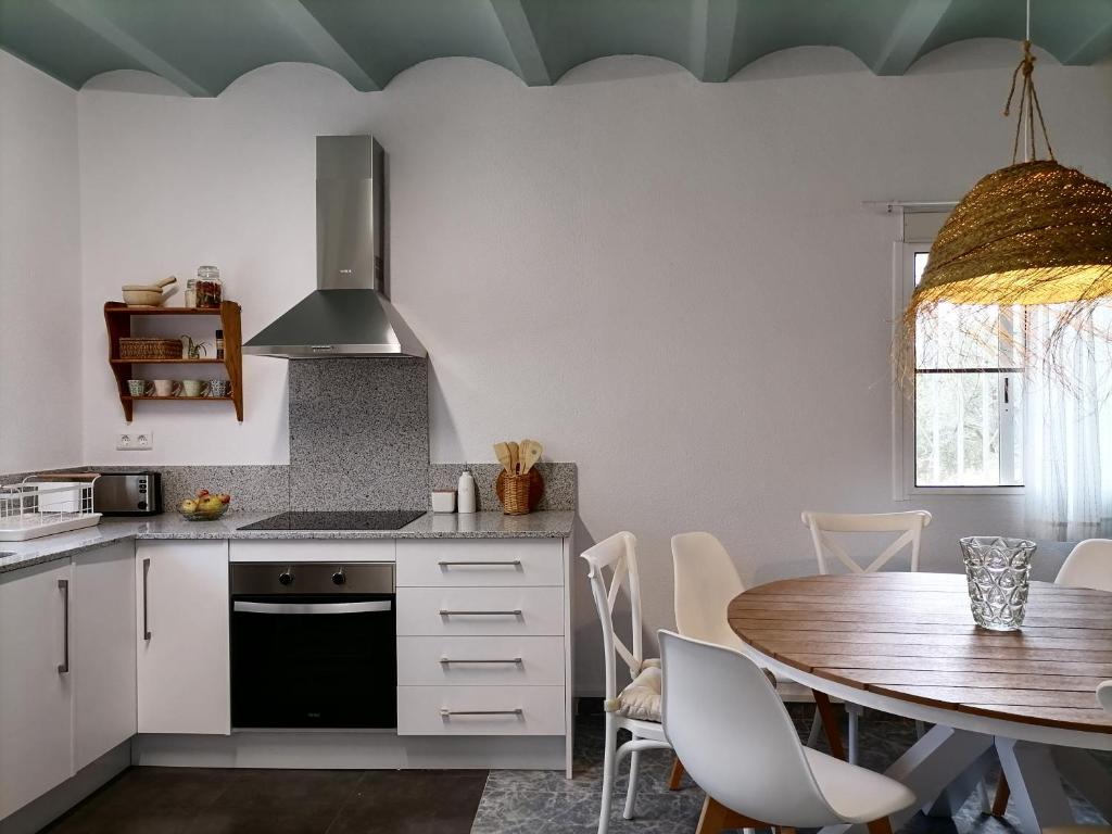 a kitchen with a table and a dining room at Masia Rosalia in L'Aldea