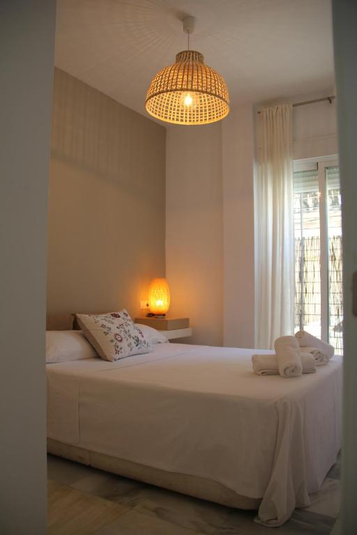 科爾多瓦的住宿－APARTAMENTO HUERTA LA REINA，卧室配有一张带吊灯的大型白色床。