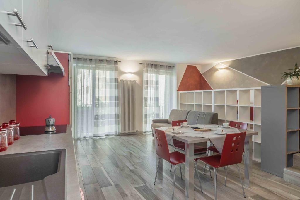 uma sala de jantar com uma mesa e cadeiras vermelhas em Appartamenti Decarli em Spormaggiore