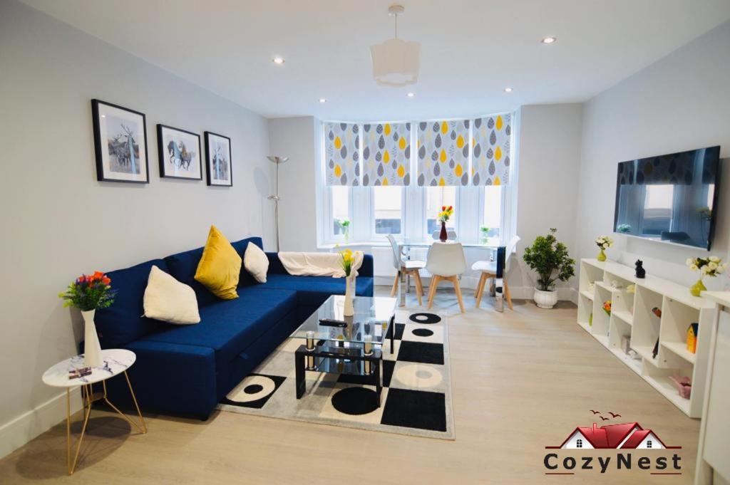 een woonkamer met een blauwe bank en een tafel bij Luxury Central Self Contained Flat by CozyNest in Reading