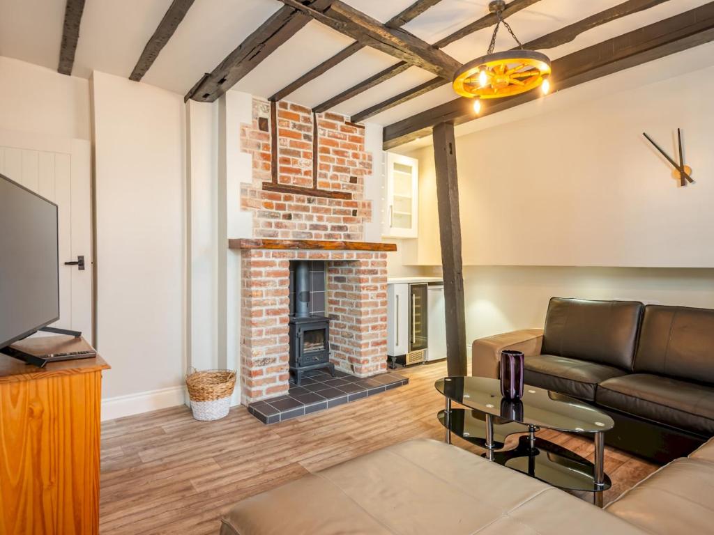 a living room with a couch and a fireplace at Pass the Keys Renovated Apartment in the Centre of Canterbury in Canterbury