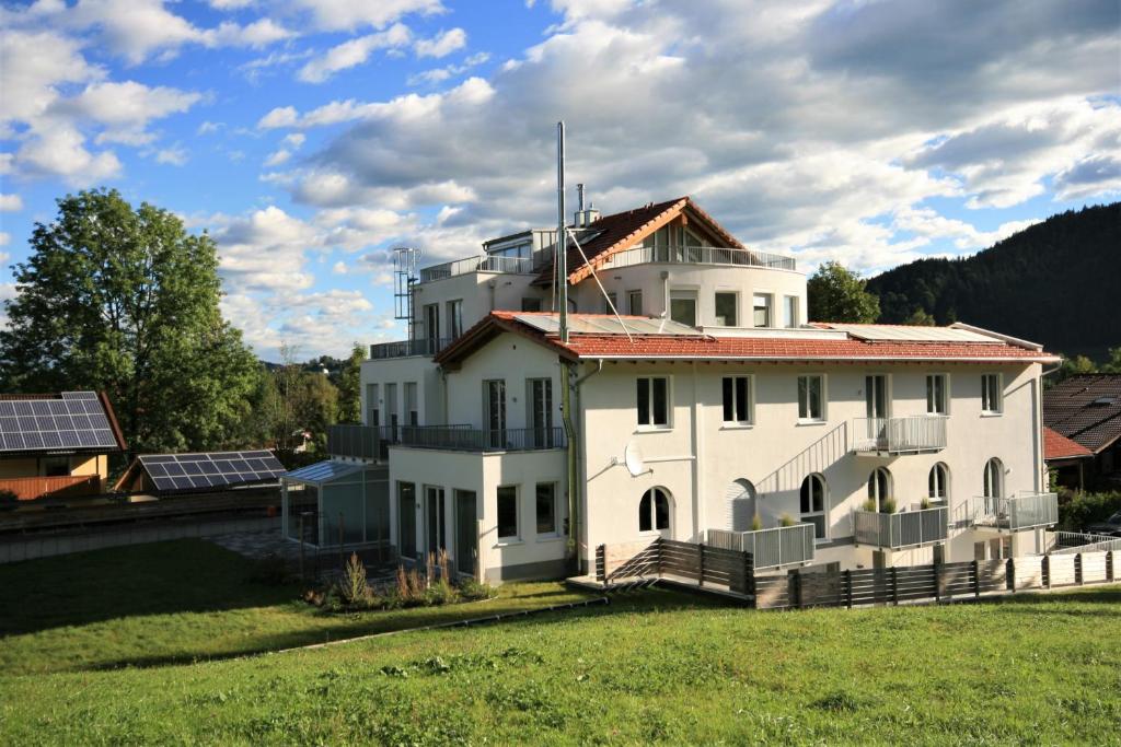 a white house with a red roof on a field at Chalet am Breitenberg Appartement CB 12 in Pfronten