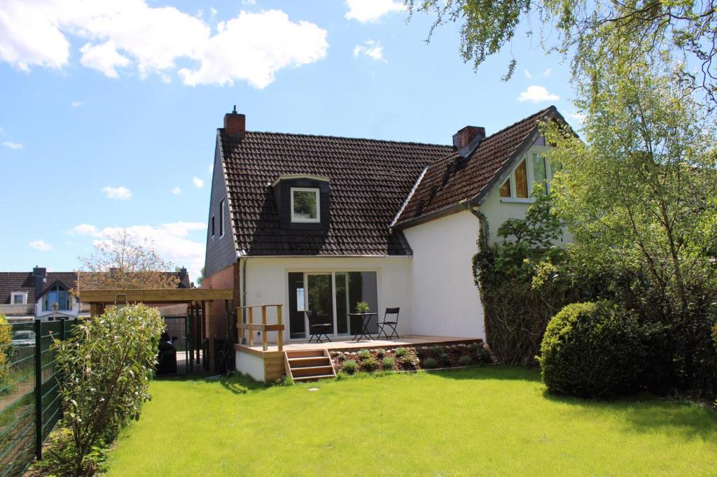 una casa blanca con una valla y un patio en Ostseetraum, en Lübeck