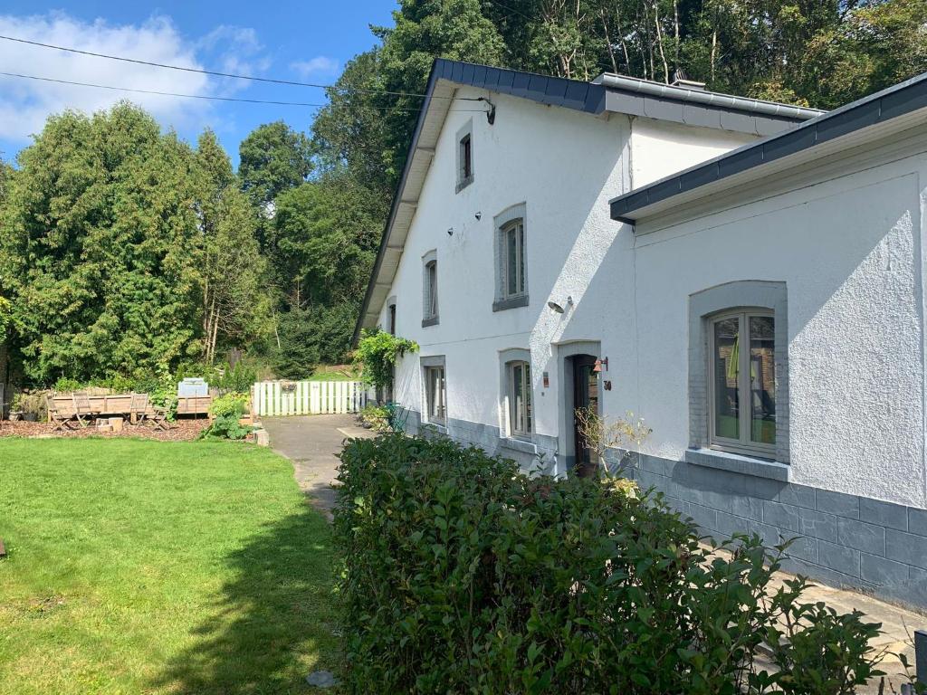 a white house with a yard next to it at B&B Le Nid d'Hirondelle in Houffalize