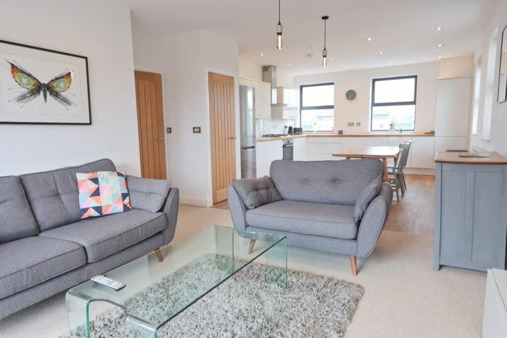 a living room with a couch and a chair and a table at Contemporary 2 Bedroom Apartment with Parking in Bristol